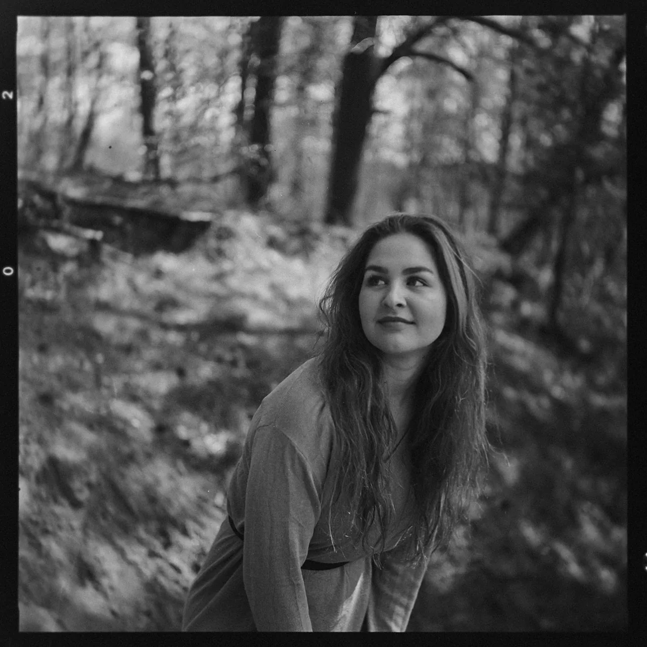 Schwarzweiß-Portrait einer Frau mit langem Haar im Wald