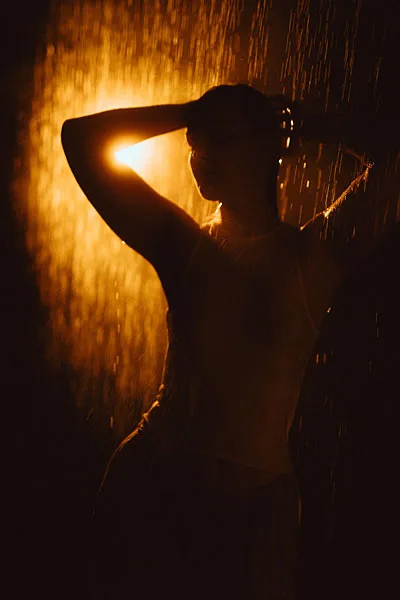 Silhouette einer Person im Regen bei warmem Gegenlicht