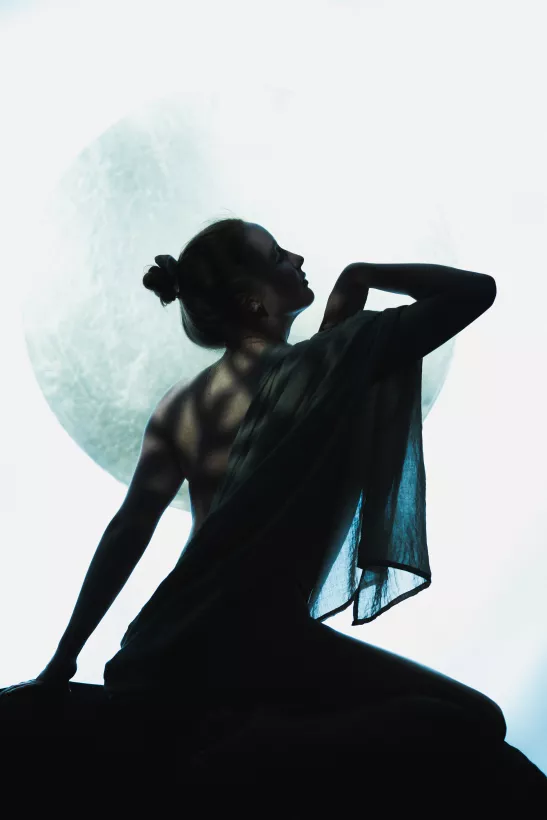 Silhouetten-Portrait einer Frau vor einem großen, hellen Lichtkreis