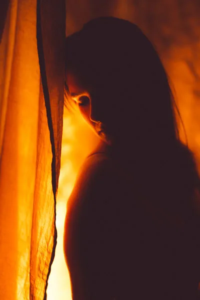 Silhouetten-Portrait einer Frau im warmen, orangefarbenen Licht.