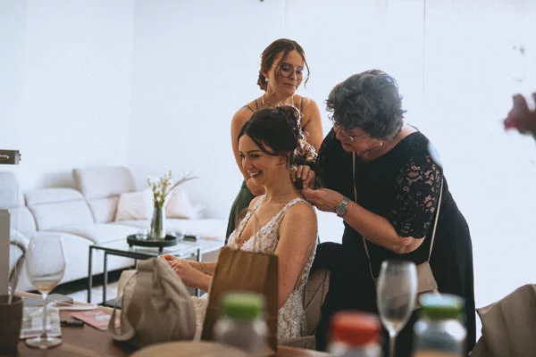 Eine Stylistin steckt der Braut während der Hochzeitsvorbereitung das Haar.