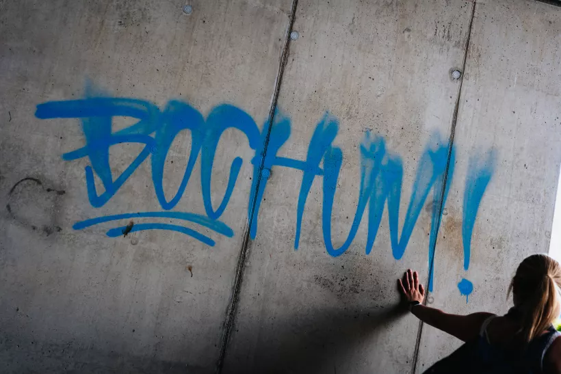 Urbaner Streetfotografie-Moment mit blauem Graffiti auf einer Betonwand.